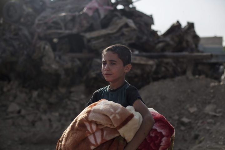 In this Oct. 9, 2017, Osama Younes cries as the body of his 15-year-old sister Sana is exhumed for forensic investigation in Mosul.
