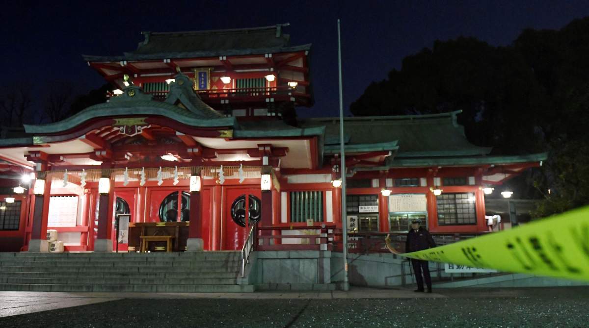 A policeman stands guard in front of the main temple of the Tomioka Hachimangu shrine in Tokyo, Japan in this photo taken by Kyodo on December 8, 2017. 