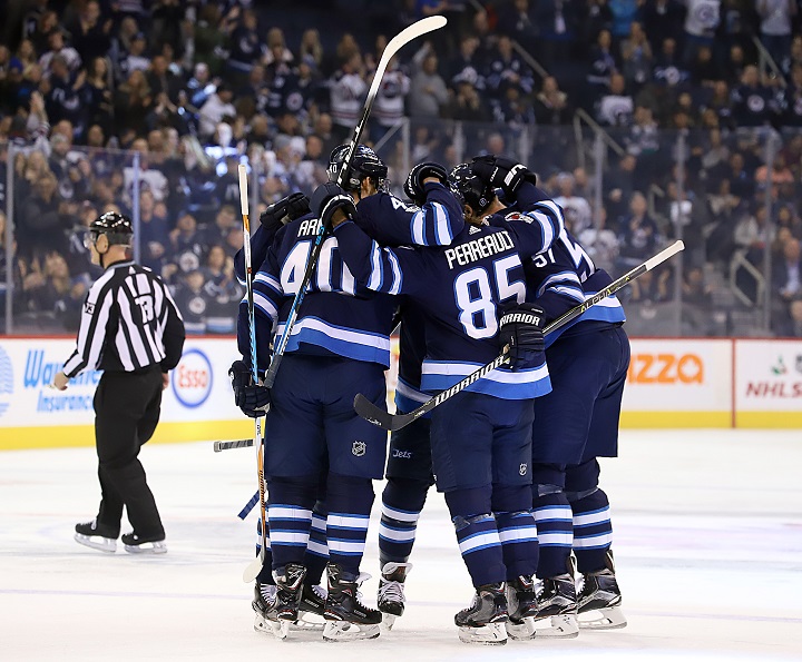 Joel Armia, Mathieu Perreault and Tyler Myers of the Winnipeg Jets celebrate a first period goal against the Vegas Golden Knights with teammates at Bell MTS Place on Dec. 1 in Winnipeg.