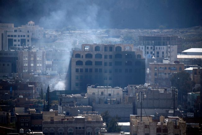 Smoke billows behind a building in the Yemeni capital Sanaa on Dec. 3, 2017, during clashes between Huthi rebels and supporters of Yemeni ex-president Ali Abdullah Saleh.