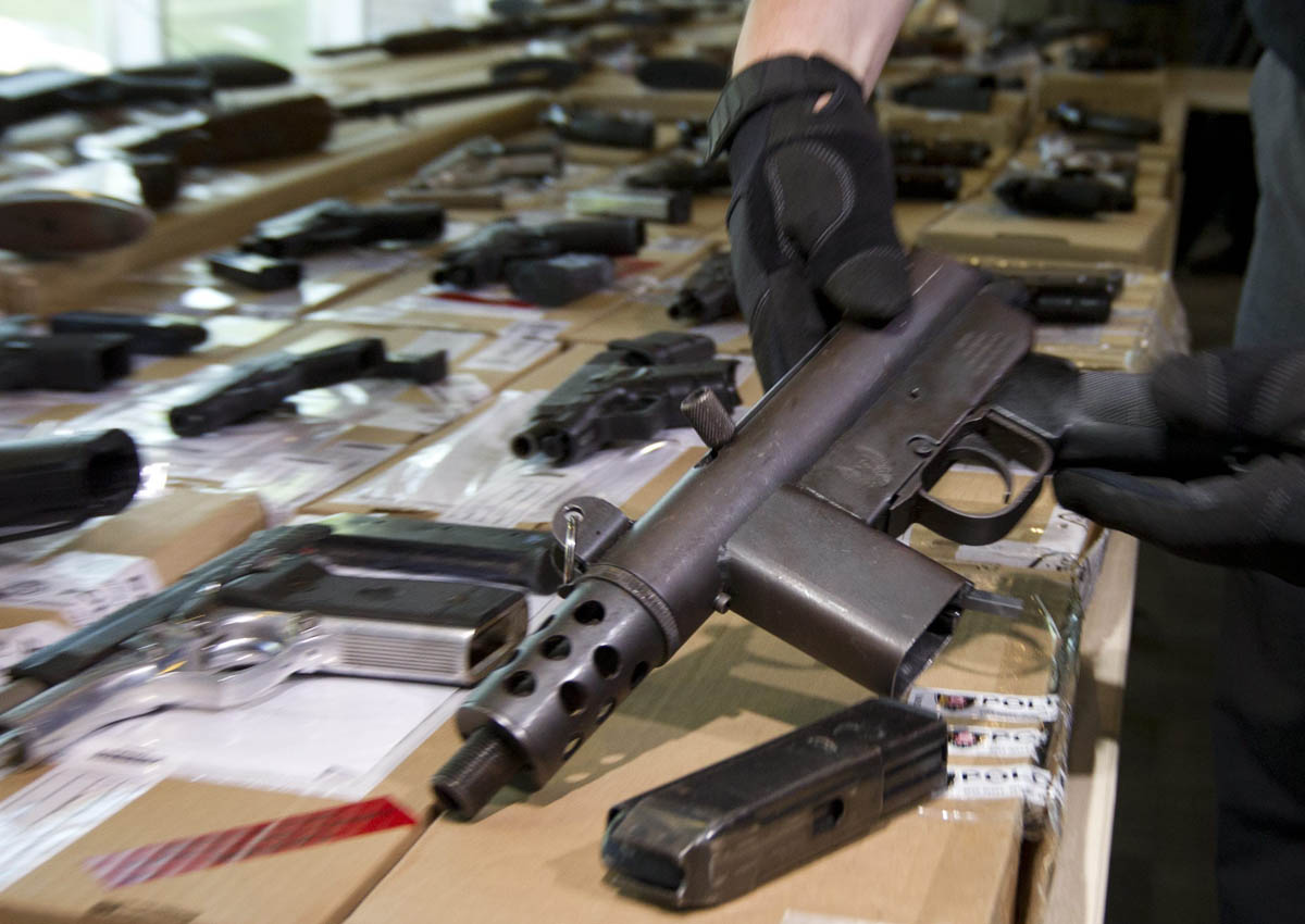 Det. Sgt. Bob Rodeghiero of the Guns and Gangs Task Force shows some of the confiscated weapons during a press conference at 23 Division in Toronto on June 14, 2014.
