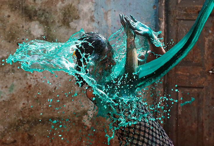A girl reacts as coloured water is thrown on her face while celebrating Holi, the Festival of Colours, in Mumbai, India, March 13, 2017.