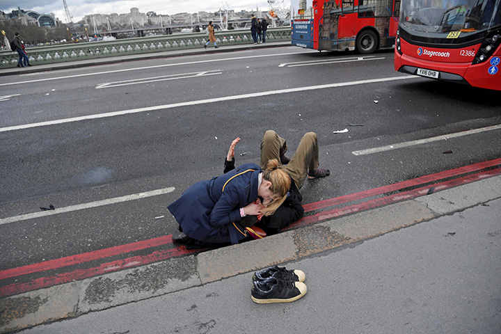A woman assists an injured person after a terror attack on Westminster Bridge in London, Britain, March 22, 2017.