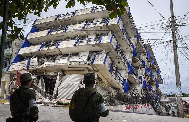 Soldiers stand guard a few metres away from a hotel that collapsed following a powerful earthquake that struck Mexico, September 8, 2017.