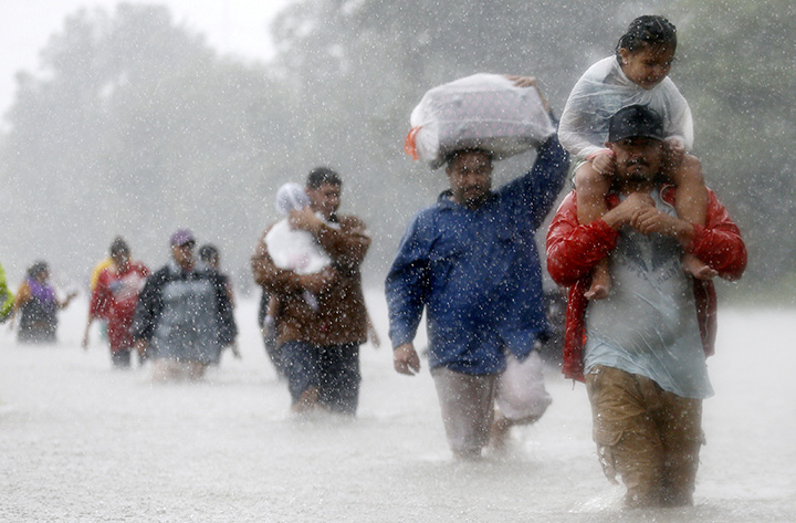 Residents wade through floodwaters from Tropical Storm Harvey in Houston, Texas, on August 28, 2017.