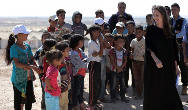 Actress and UN refugee agency envoy special envoy Angelina Jolie smiles at children during a visit to a Syrian refugee camp in Azraq in northern Jordan, Sept. 9, 2016. 

