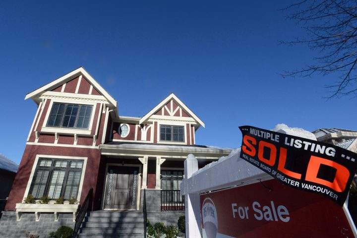 A real estate sold sign is shown outside a house in Vancouver, Tuesday, Jan.3, 2017.  