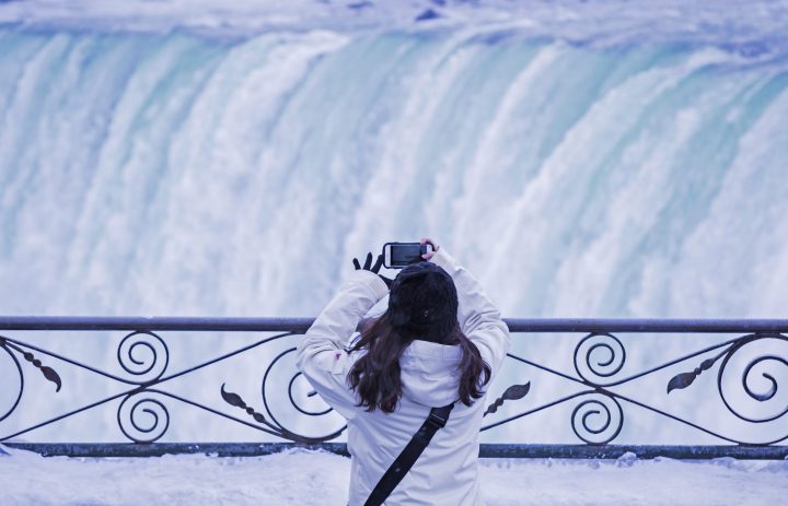 A visitor takes a photograph at the brink of the Horseshoe Falls in Niagara Falls, Ont. on Dec. 29, 2017.