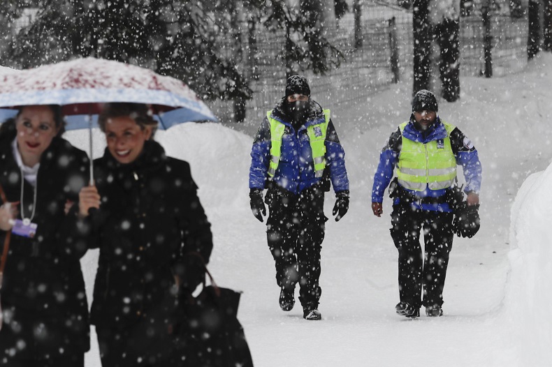 Two police officers patrol through the snow near the congress centre where the World Economic Forum, WEF, will take place in Davos, Monday, Jan. 22, 2018.