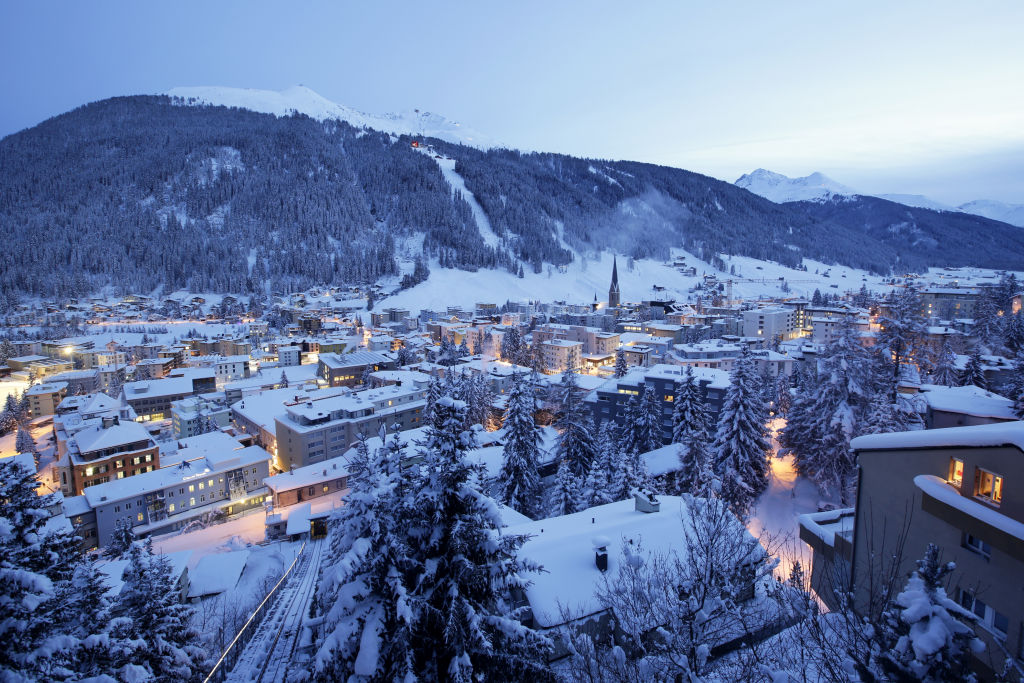 St. John's church, centre right, sits surrounded by snow-covered residential buildings as night falls in Davos, Switzerland, on Monday, Jan. 18, 2015.