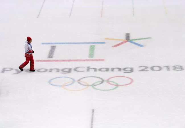 A worker walks across the Pyeongchang 2018 logo in the figure skating venue during the XXIII Olympic Winter Games in Gangneung, South Korea on Thursday, February 8, 2018. 
