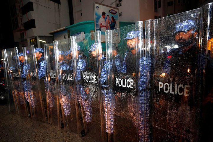 Maldivian police stand guard on a main street during a protest by opposition supporters on Feb. 5.