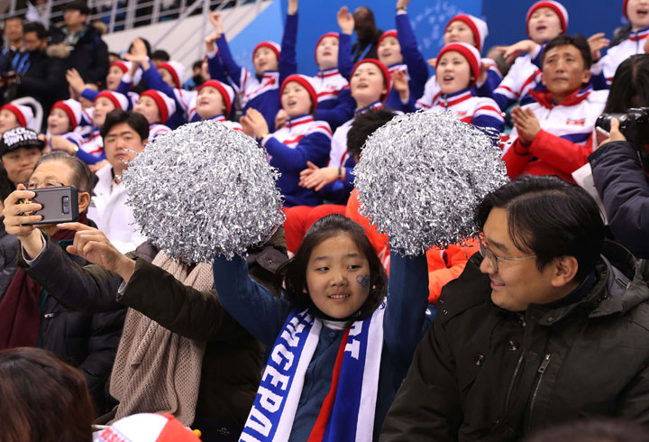 Fans cheer with North Korean cheerleaders.