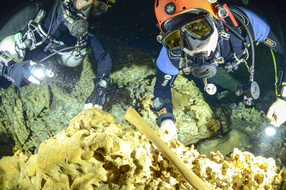 This undated photo released by Mexico’s National Anthropology and History Institute (INAH), shows divers from the Great Mayan Aquifer project exploring the Sac Actun underwater cave system where Mayan and Pleistocene bones and cultural artifacts have been found submerged, near Tulum, Mexico.
