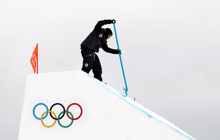 An Olympics official works on the slope after the women’s snowboard slopestyle qualification round was cancelled due to heavy wind. 