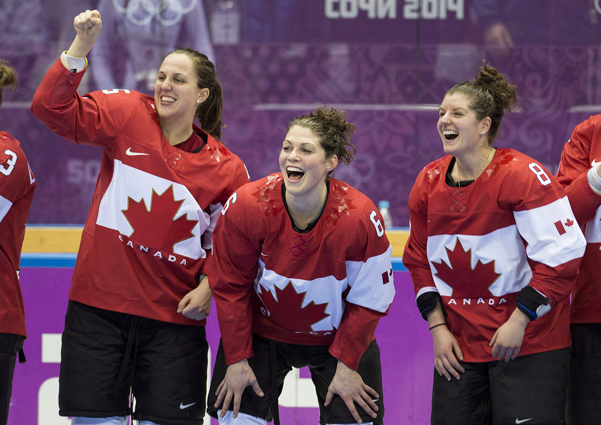 Canada’s Lauriane Rougeau, Rebecca Johnston, and Laura Fortino, left to right, celebrate after beating the USA 3-2 in overtime to win the gold medal in the women’s hockey final at the Sochi Winter Olympics Thursday, February 20, 2014 in Sochi.