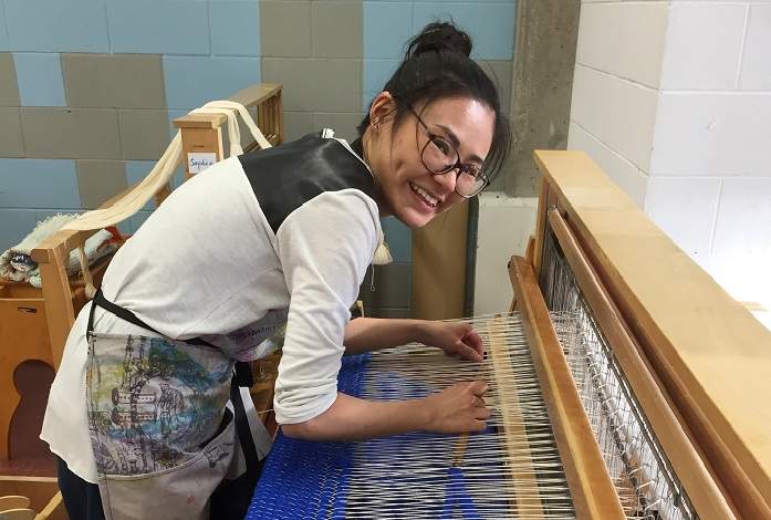 ACAD student Yilu Xing working on the sweater for Kensington’s Chicken on the Way chicken statue.