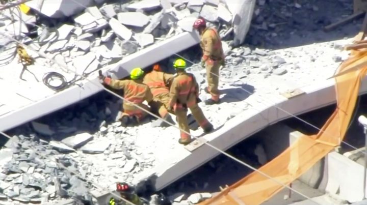 Emergency crews look for victims at the scene of a collapsed pedestrian bridge at Florida International University.
