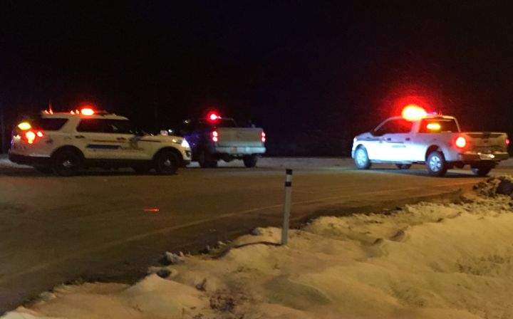 Emergency vehicles are seen on Highway 16 near Entwistle, Alta. on Thursday night after sources say a man wanted for murder was killed in the area and an RCMP officer was injured after shots were exchanged.