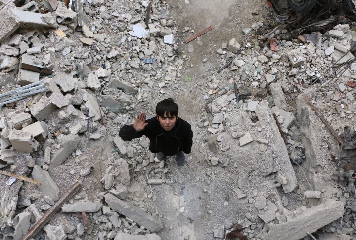 A Syrian boy raises his hand as he poses for a photo for the awareness campaign #Iamstillalive.