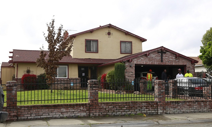 People gather outside the home, Wednesday, March 21, 2018, where Stephon Alonzo Clark, 22, was shot and killed by a pair of Sacramento Police officers in Sacramento, Calif.
