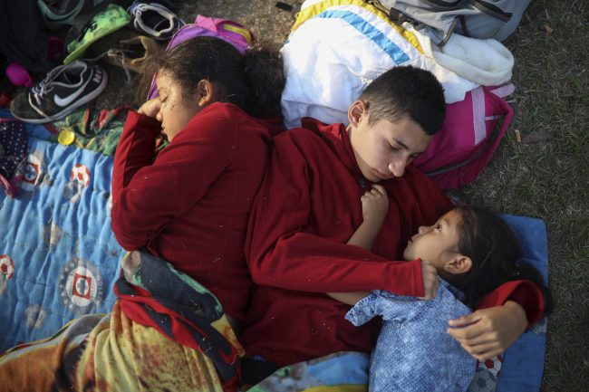 A trio of El Salvadorean siblings huddle together on a soccer field that served as a camp for migrants traveling with the “Stations of the Cross” caravan in Matias Romero, Mexico, April 4, 2018.