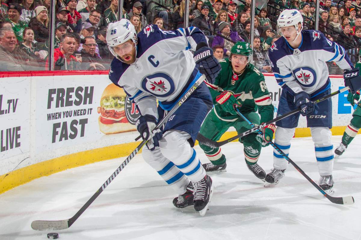 Blake Wheeler and Bryan Little of the Winnipeg Jets battle for the puck with Mikael Granlund of the Minnesota Wild during a game earlier this year. The Wild cut the Jets first-round series lead in half Sunday after a 6-2 victory.