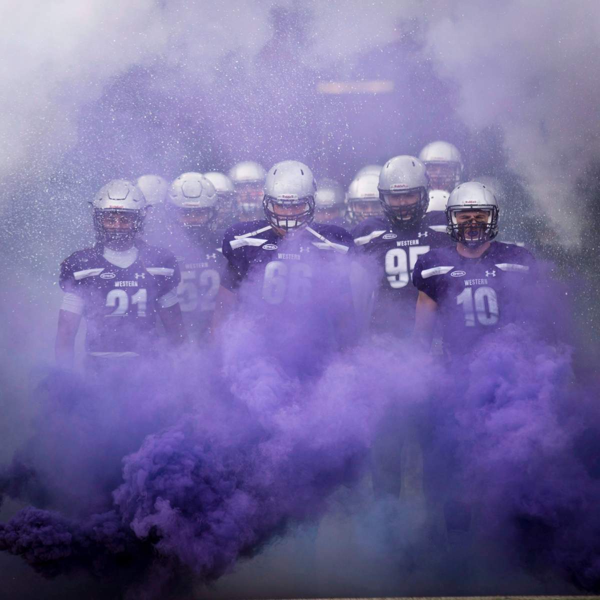 Offensive lineman David Brown, middle, running back Cedric Joseph, left, and linebacker Jean Gabriel Poulin, right, lead the Western Mustangs onto the field prior to their Vanier Cup football game victory over the Laval Rouge et Or in Hamilton, Ont., on Nov. 25, 2017. 