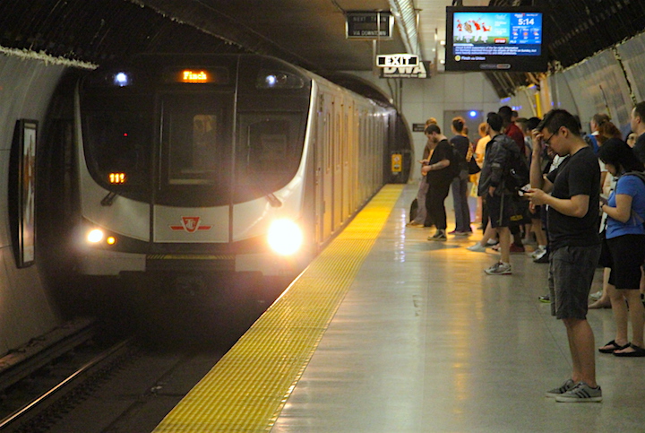 Passengers wait to board a southbound TTC Line 1 subway train.