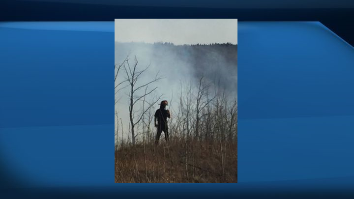 Firefighters monitor a grass fire in Windermere Saturday.