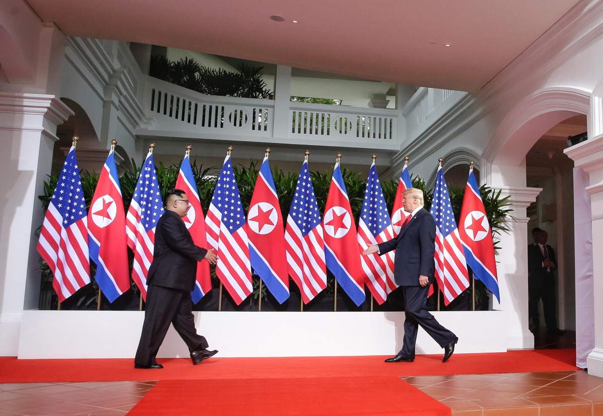 U.S. President Donald J. Trump (R) and North Korean leader Kim Jong-un (L) walk towards each other to shake hands at the start of a historic summit at the Capella Hotel on Sentosa Island, Singapore, 12 June 2018.