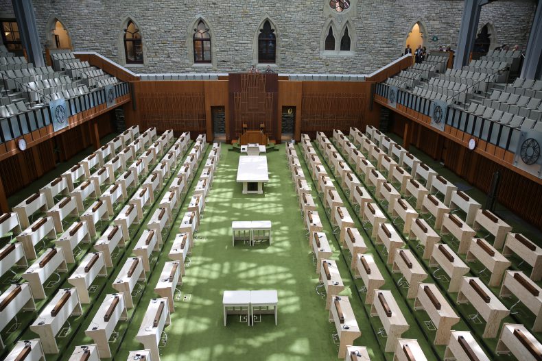 A shot of the House of Commons looking toward the Speaker’s chair. This photo shows placeholder desks made of plywood, but the current furniture from Centre Block will be moved into the space. The public galleries in the new space are also smaller with seating for 346 persons as opposed to 581.