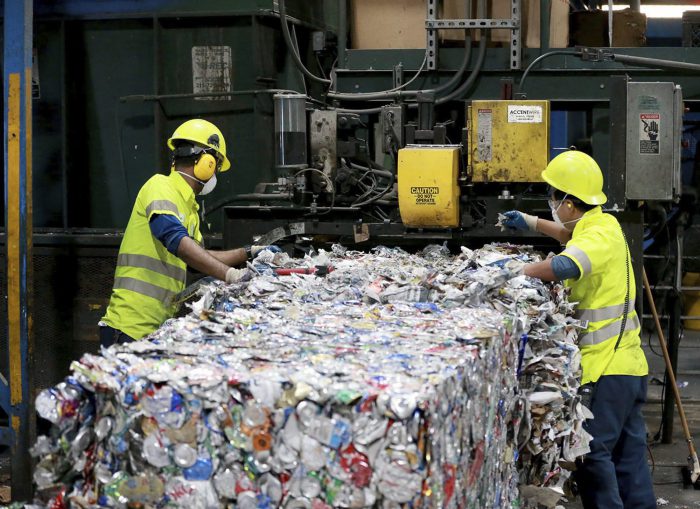 In this Thursday, Nov. 2, 2017 file photo, workers at ACUA recycling center pull plastic contaminants out of the recycling stream in Egg Harbor Township, N.J.