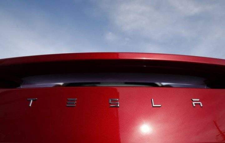 In this April 15, 2018, file photo the sun shines off the rear deck of a roadster on a Tesla dealer’s lot in the south Denver suburb of Littleton, Colo.