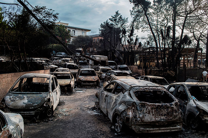 This photo taken on July 24, 2018 show cars burnt following a wildfire at the village of Mati, near Athens, on July 24, 2018.