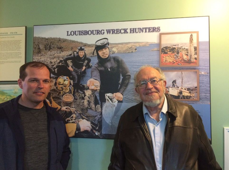 Alex Storm, right, poses with his son Jason Storm in front of a display about him and his treasure hunting days in this undated handout photo. 