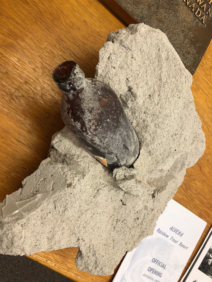 A beer bottle is shown embedded in concrete in this handout image.