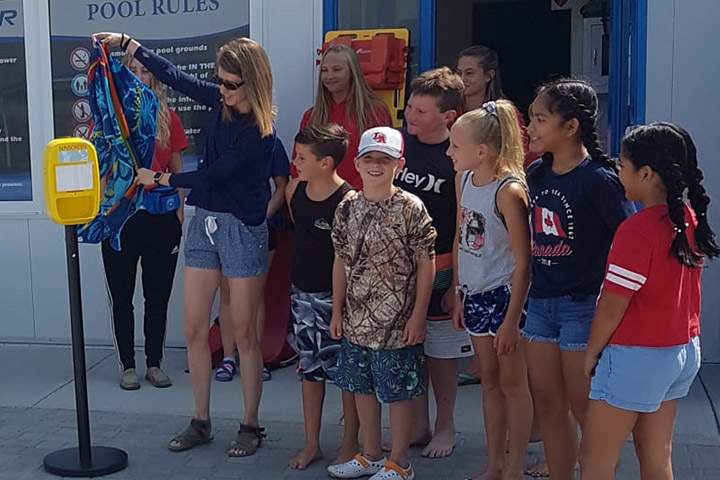 Meagan Greene and her Grade 4 students at the unveiling of a free sunscreen dispenser at the Panther Swimming Pool in Davidson, Sask.