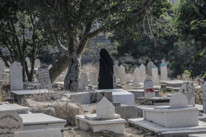 Palestinians visit the grave of their relatives at the cemetery on the first day of Eid al Adha in Gaza City, 21 August 2018.