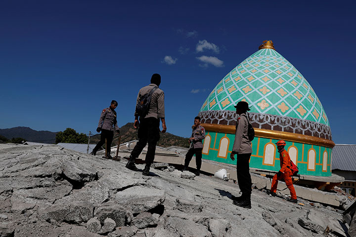Rescuers and policemen walk on top of a collapsed mosque as they try to find survivors after an earthquake hit on Sunday in Pemenang, Lombok Island, Indonesia, August 7, 2018.