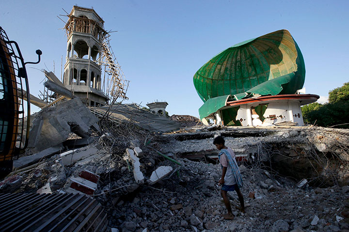 A resident inspects a mosque damaged by an earthquake in North Lombok, Indonesia, Tuesday, Aug. 7, 2018.