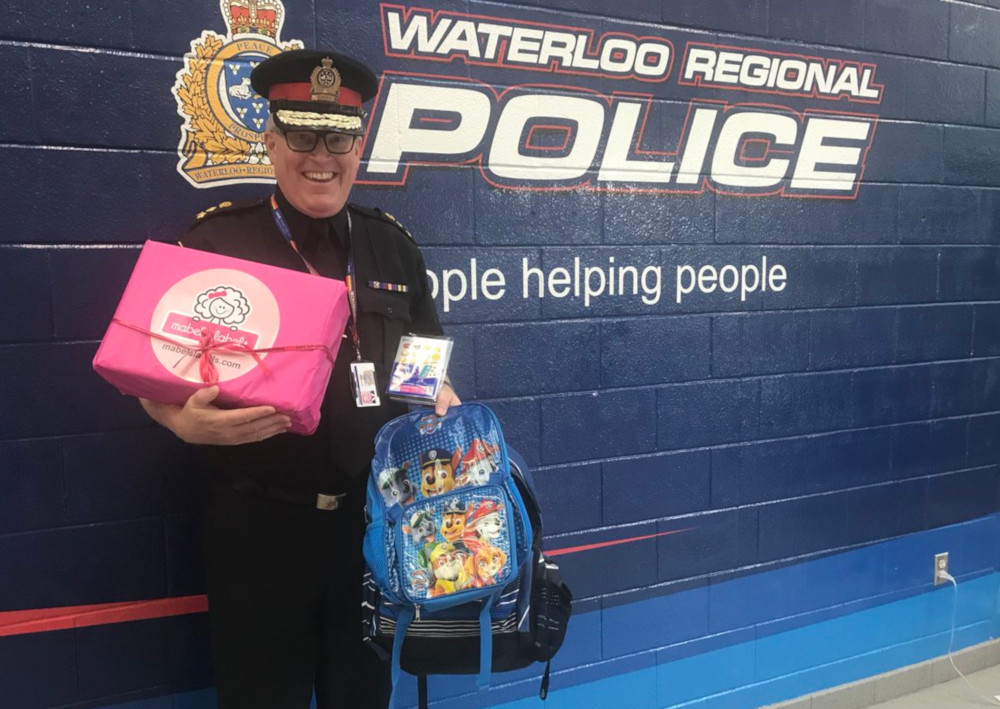 Waterloo police Chief Bryan Larkin with a couple of the more-than-1,400 backpacks that were donated.