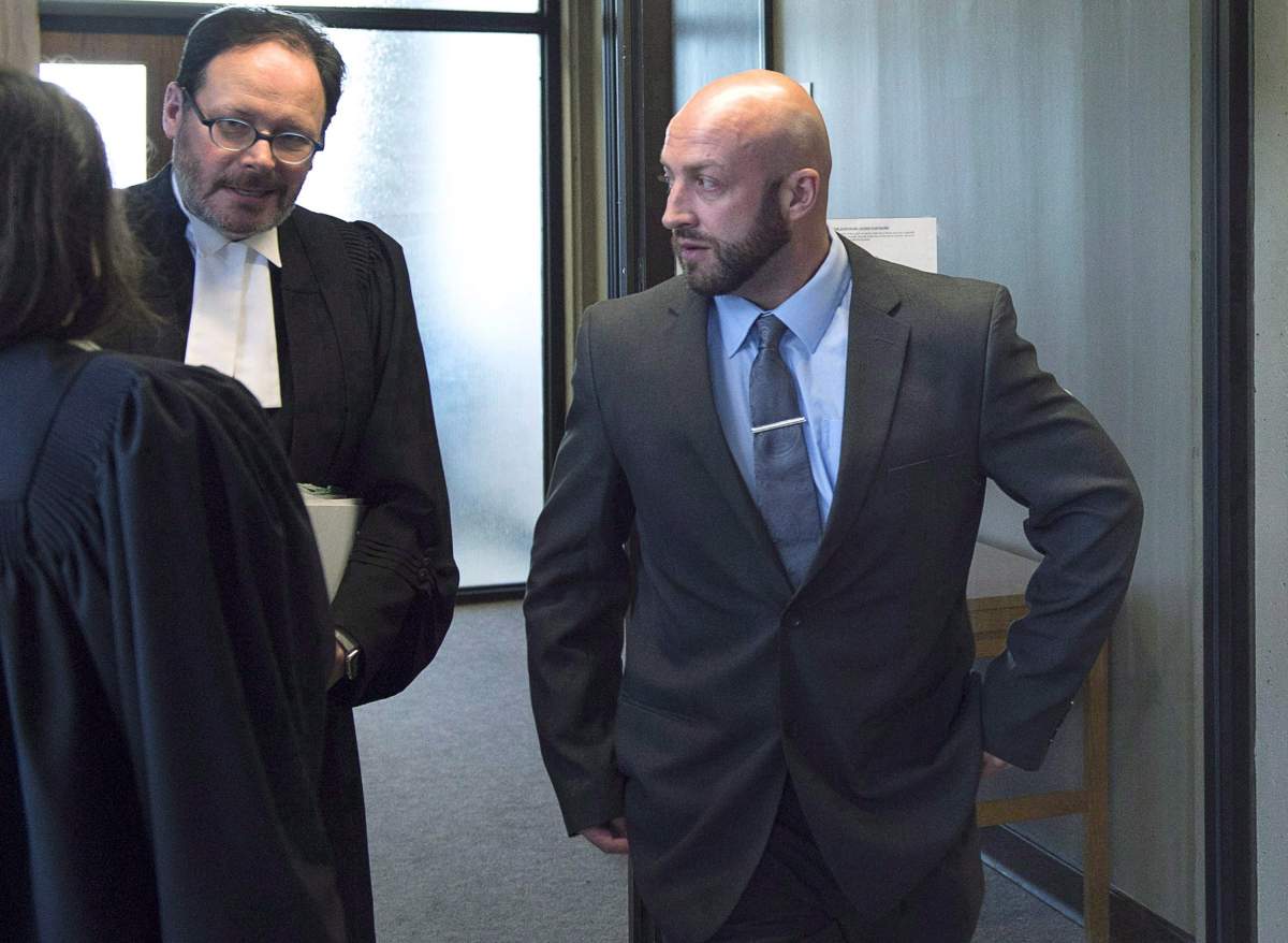 Darren Smalley, right, a British sailor charged with sexual assault causing bodily harm, walks outside the court room in Nova Scotia Supreme Court in Halifax on Wednesday, Sept. 5, 2018. 