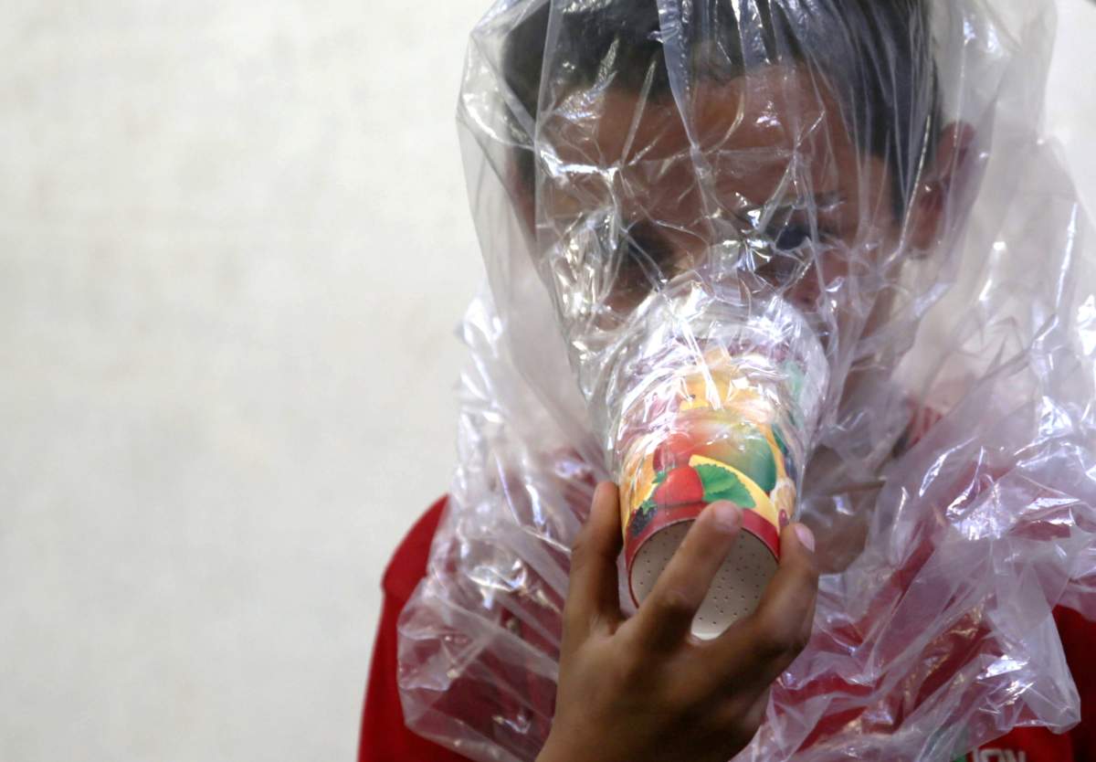 A boy tries on an improvised gas mask in Idlib, Syria September 3, 2018. Picture taken September 3, 2018.