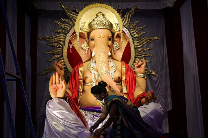 A woman fixes ornaments of an idol of the Hindu god Ganesha, the deity of prosperity in India, Sept. 12, 2018.