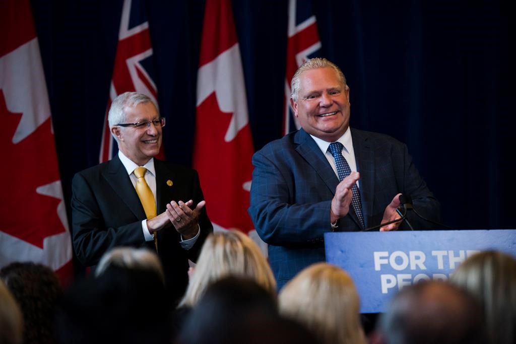 Finance Minister Vic Fedeli applauds alongside Premier Doug Ford after speaking to members of his caucus in Toronto on Monday, Sept. 24, 2018. 