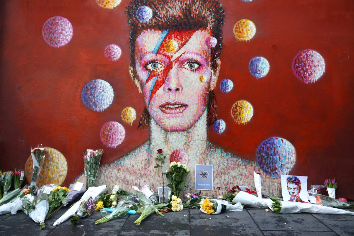 Flowers are laid beneath a mural of David Bowie in Brixton on January 11, 2016.