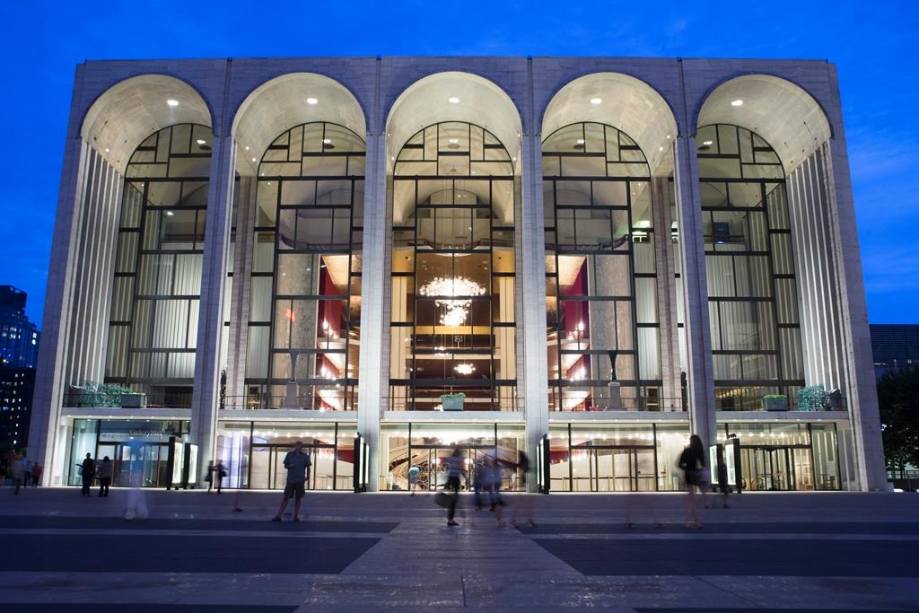 FILE – In this Aug. 1, 2014, file photo, pedestrians make their way in front of the Metropolitan Opera house at New York’s Lincoln Center. The Metropolitan Opera will start regular Sunday afternoon performances for the first time in its century-plus history during the 2019-20 season. (AP Poto/John Minchillo, File)