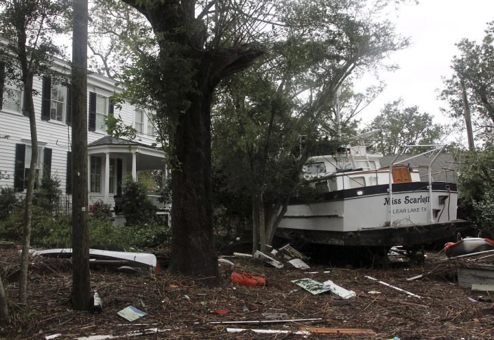 A 40-foot yacht lies in the yard of a storm-damaged home on East Front Street in New Bern, N.C., Saturday, Sept. 15, 2018.