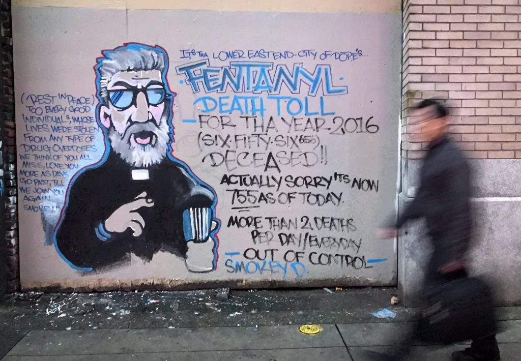 A man walks past a mural by street artist Smokey D. painted as a response to the fentanyl and opioid overdose crisis, in the Downtown Eastside of Vancouver, B.C., on Thursday, December 22, 2016. 